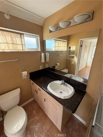 a bathroom with a toilet sink and mirror