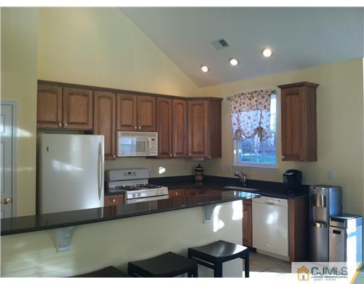 12 Hartack Road Manalapan, NJ 07726 - Photo 3 of 23 a kitchen with granite countertop a stove a refrigerator a sink a oven with wooden cabinets
