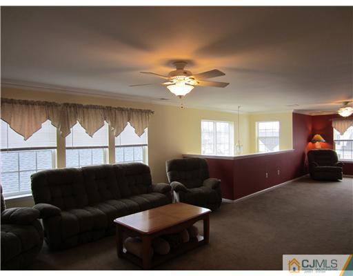 12 Hartack Road Manalapan, NJ 07726 - Photo 7 of 23 a living room with furniture a chandelier and a window