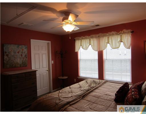 12 Hartack Road Manalapan, NJ 07726 - Photo 9 of 23 a bedroom with a bed and a chandelier