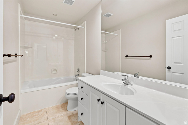 689 Apple Drive Logan, UT 84321 - Photo 23 of 52 Bathroom featuring a white vanity with integrated sink, a rectangular mirror, a shower-over-tub combination with a clear glass enclosure, and light-toned tile flooring