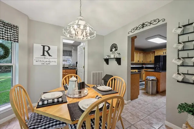 a dining room with furniture a chandelier and window