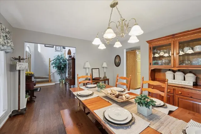 a view of a dining room with furniture a chandelier and wooden floor