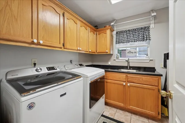 a utility room with sink dryer and washer
