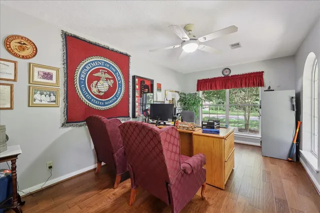 a dining room with furniture a window and wooden floor
