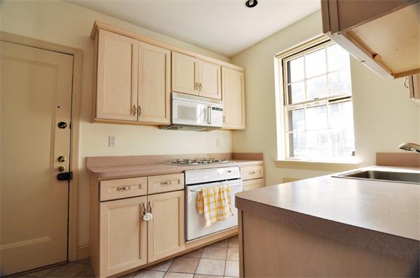 1498 Beacon Street, Unit 4 Brookline, MA 02446 - Photo 7 of 8 a kitchen that has a lot of cabinets in it and wooden floors
