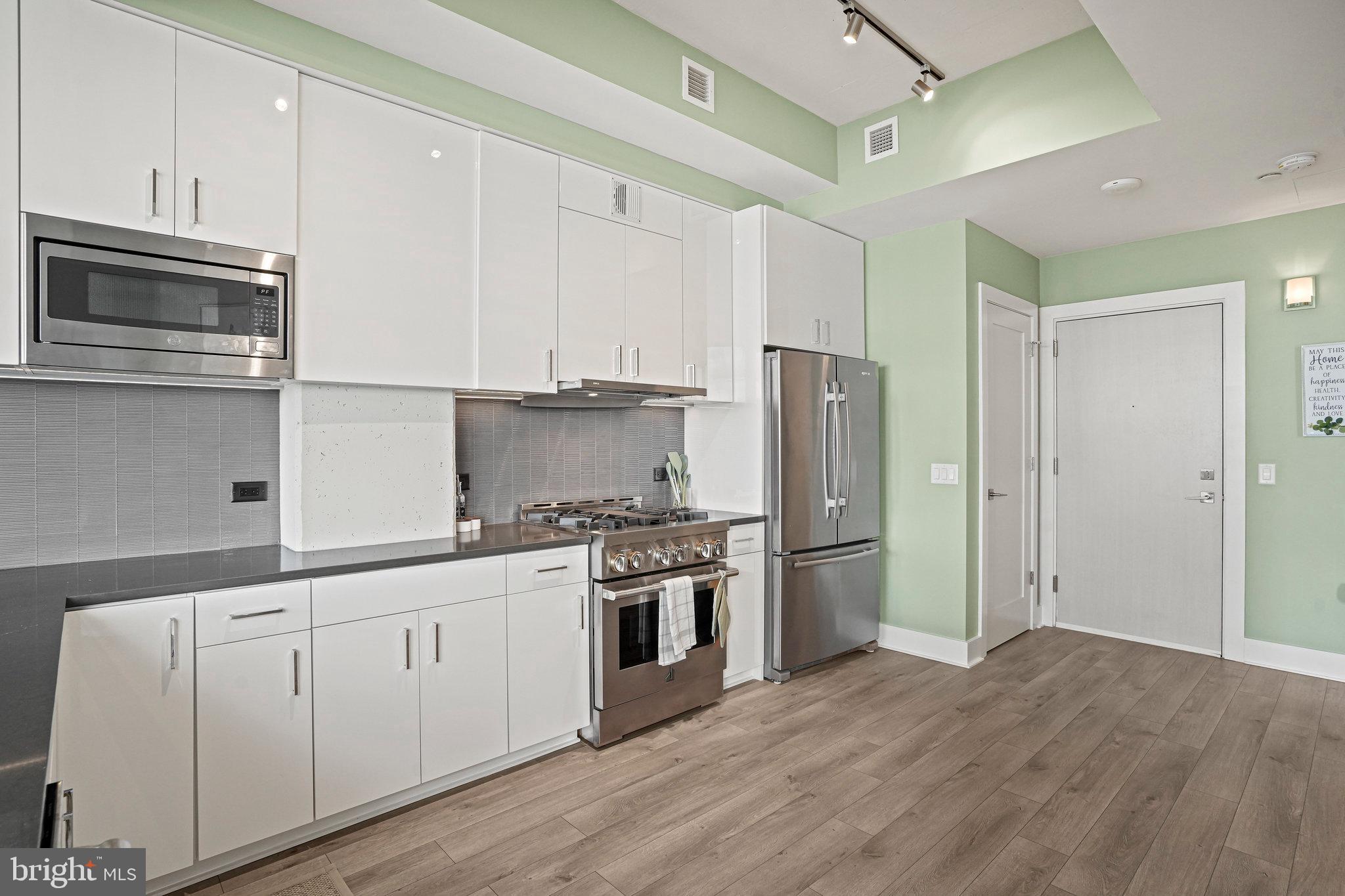 88 V Street Southwest, Unit 807 Washington, DC 20024 - Photo 14 of 57 a kitchen with cabinets stainless steel appliances and wooden floor