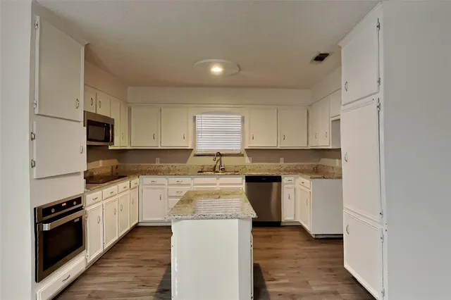 a kitchen with a stove top oven sink and cabinets
