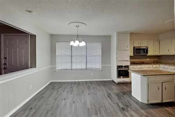 a view of a kitchen counter space wooden floor and a window