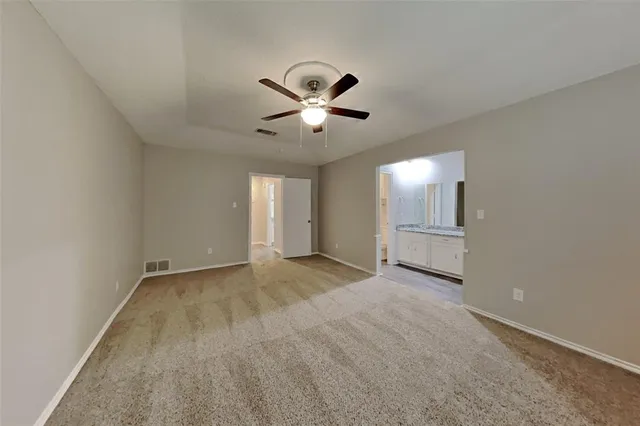 a view of an empty room and a ceiling fan