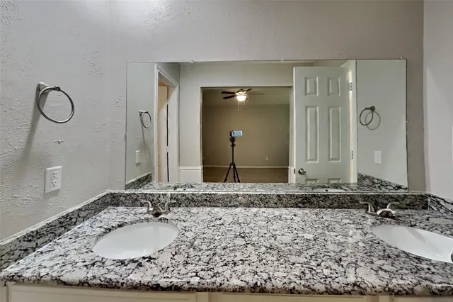 a bathroom with a granite countertop sink and a mirror
