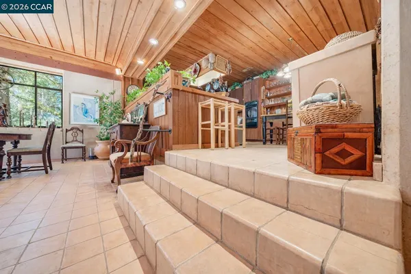 a living room with furniture a fireplace and large windows