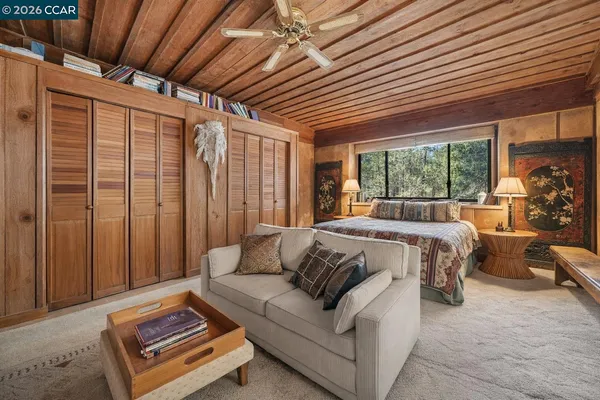 a bed sitting in a bedroom next to a window