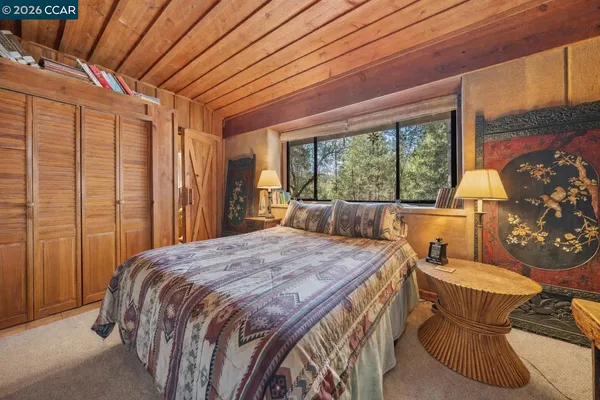 a spacious bedroom with a bed and a dresser