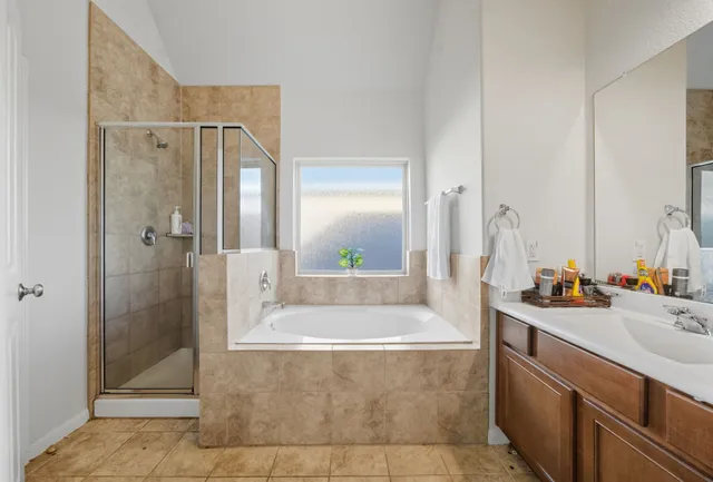 a bathroom with a tub a sink and mirror