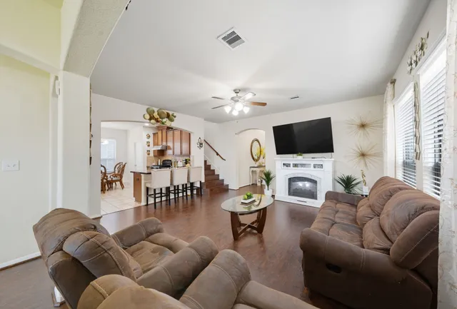 a living room with furniture a flat screen tv and a window
