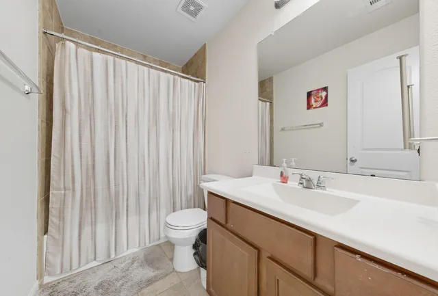 a bathroom with a sink a toilet and shower curtain