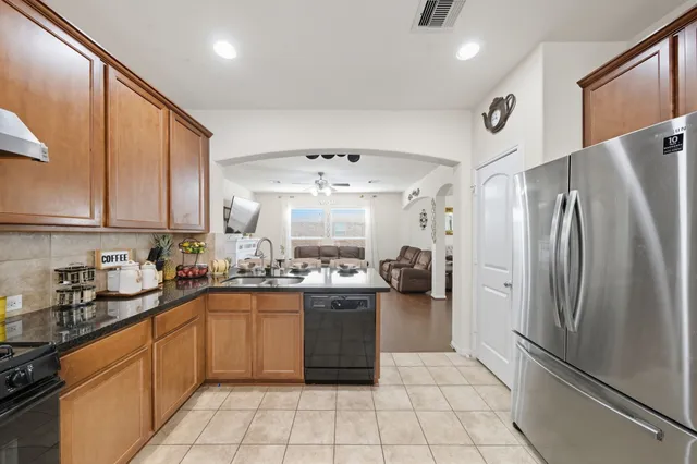 a kitchen with stainless steel appliances granite countertop a refrigerator and a sink