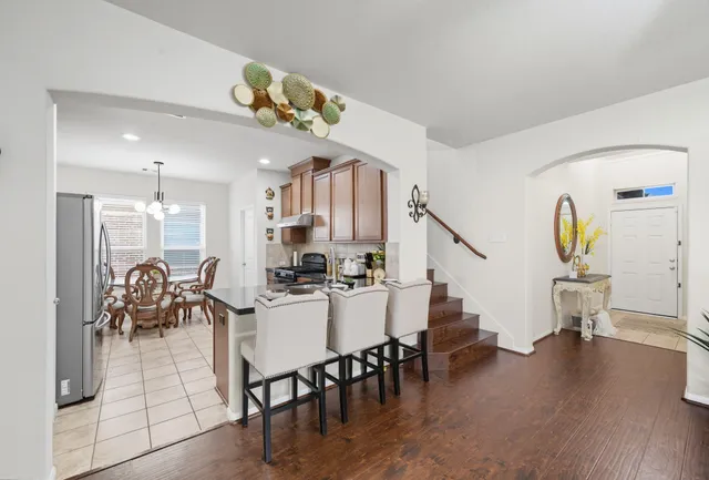 a view of a dining room with furniture a chandelier and wooden floor