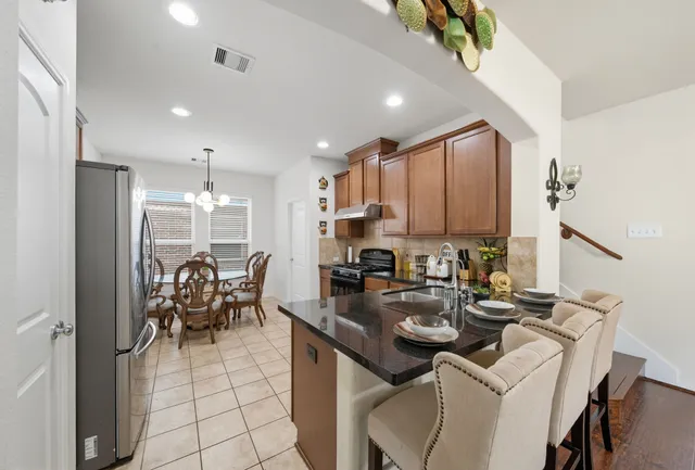 a kitchen with a dining table chairs and a refrigerator