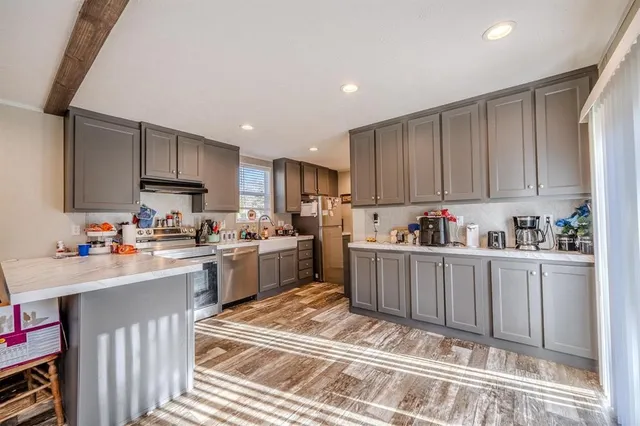 a kitchen with granite countertop a sink stove top oven and cabinets