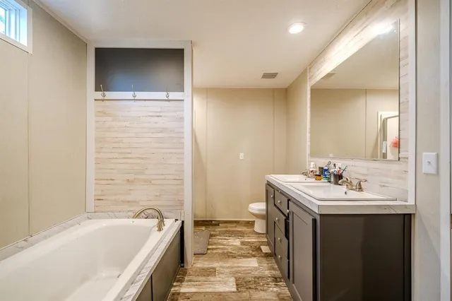a bathroom with a tub sink and mirror