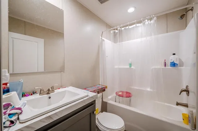 a bathroom with a sink toilet vanity and tub