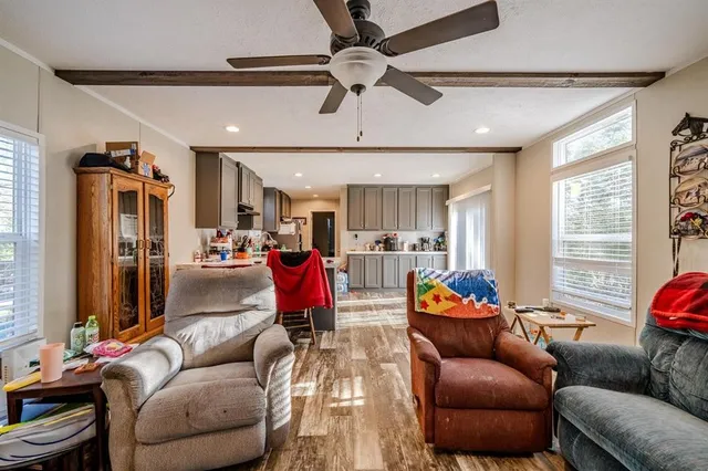 a living room with furniture kitchen view and a window