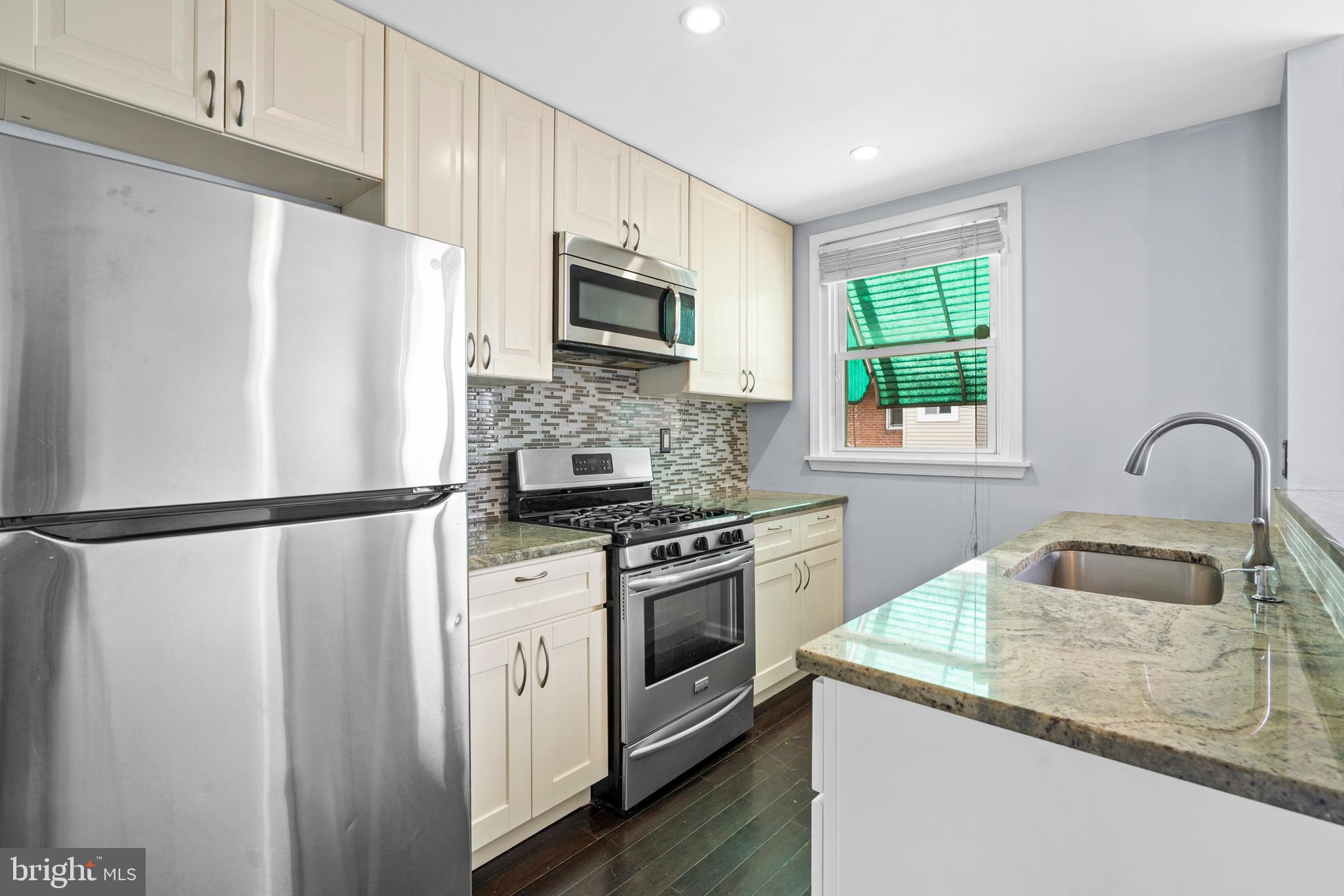 3522 Meridian Street Philadelphia, PA 19136 - Photo 7 of 18 a kitchen with stainless steel appliances a refrigerator sink microwave and stove