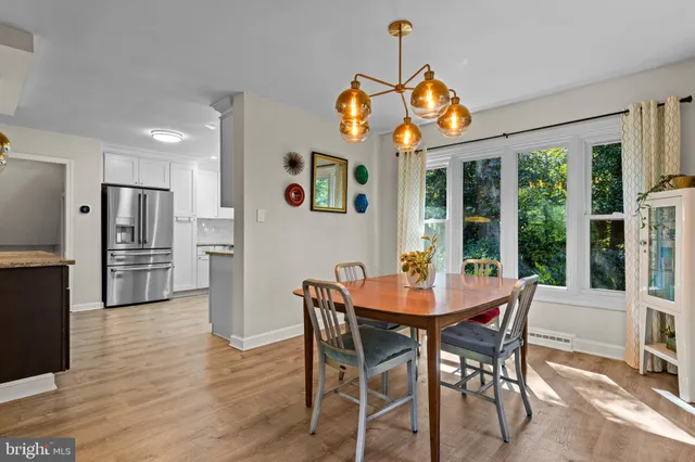 a dining room with furniture a chandelier and wooden floor