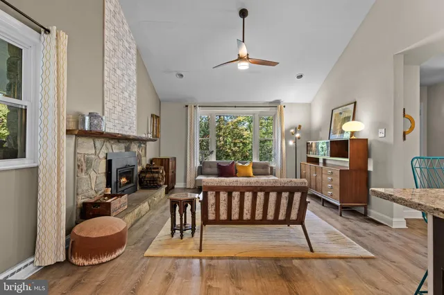 a living room with furniture a fireplace and a chandelier