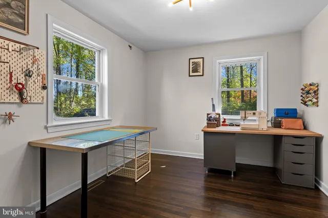 a view of a workspace with furniture and a window