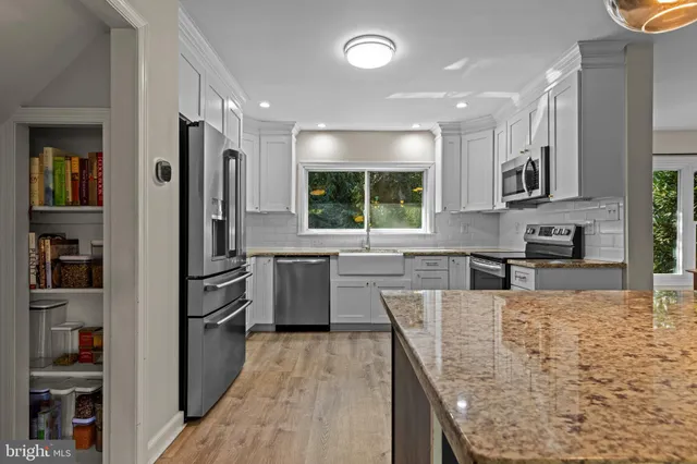 a kitchen with stainless steel appliances granite countertop a refrigerator sink and stove