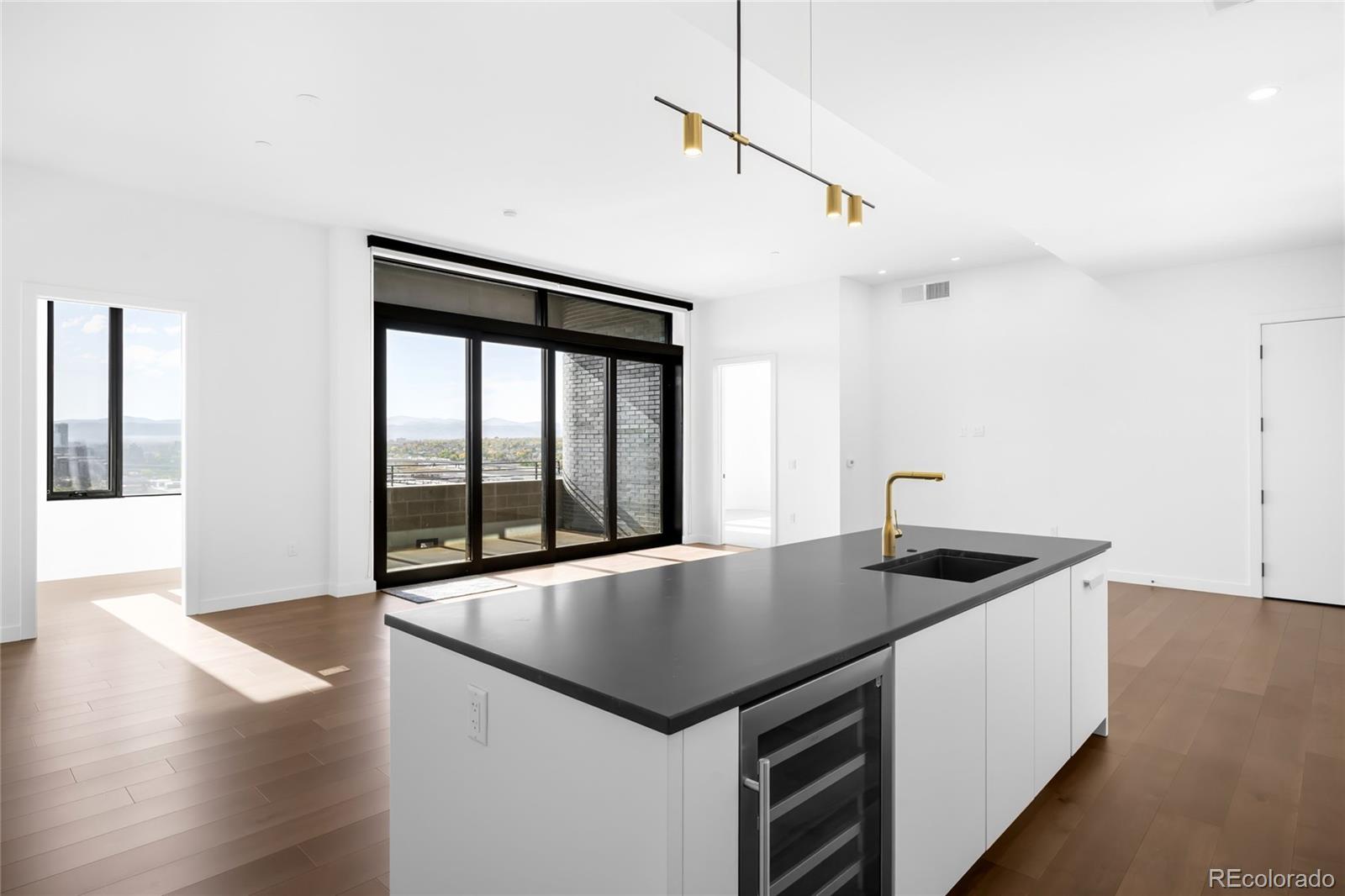 3520 Chestnut Place, Unit PH1207 Denver, CO 80216 - Photo 1 of 37 a kitchen with a stove a counter space and wooden floor