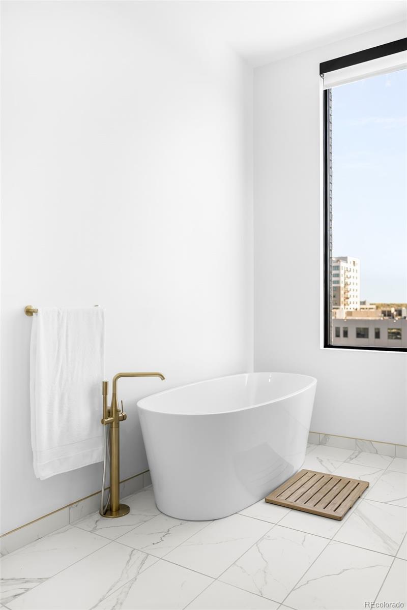 3520 Chestnut Place, Unit PH1207 Denver, CO 80216 - Photo 21 of 37 a white bath tub sitting next to a white sink