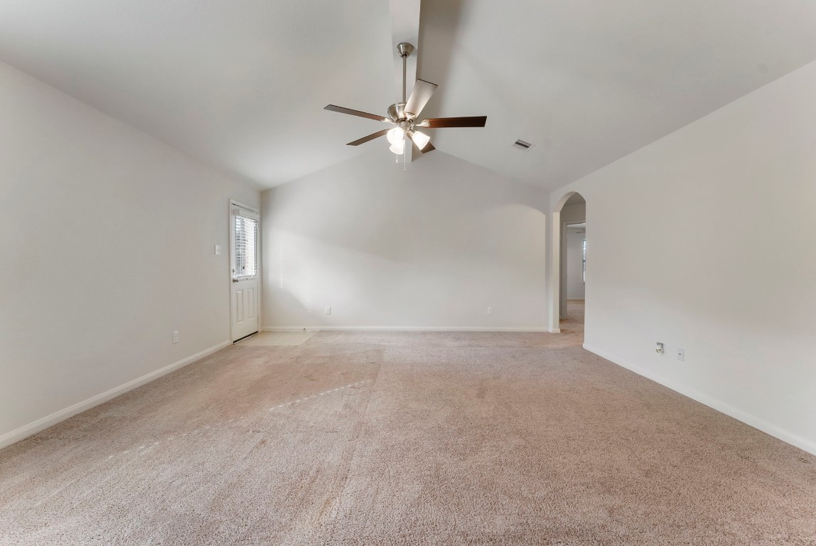 9159 Nina Road Conroe, TX 77304 - Photo 3 of 24 Continue into the expansive living room, where a door to the left opens to the large backyard. The hall to the right leads to the bedrooms, offering a thoughtful and functional layout.