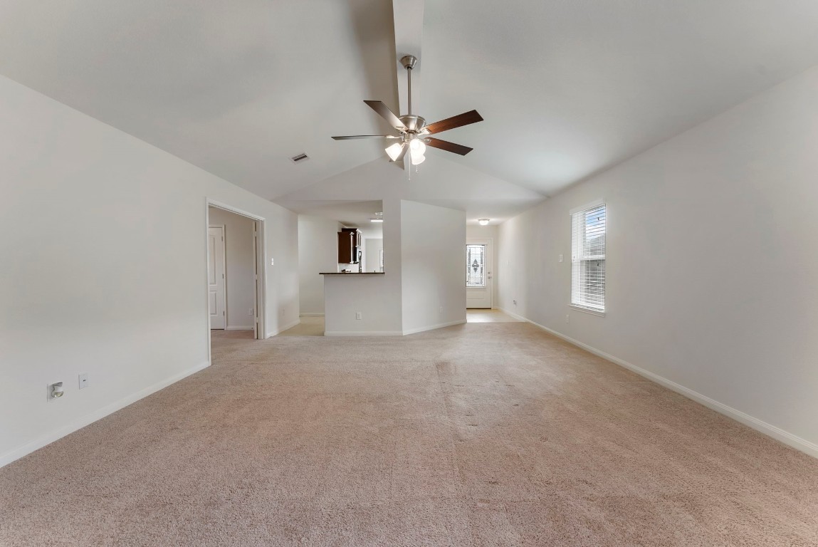 9159 Nina Road Conroe, TX 77304 - Photo 4 of 24 A wide view of the spacious living area looking toward the front entry and kitchen, with the study located to the left—showcasing the home’s open layout and natural flow.