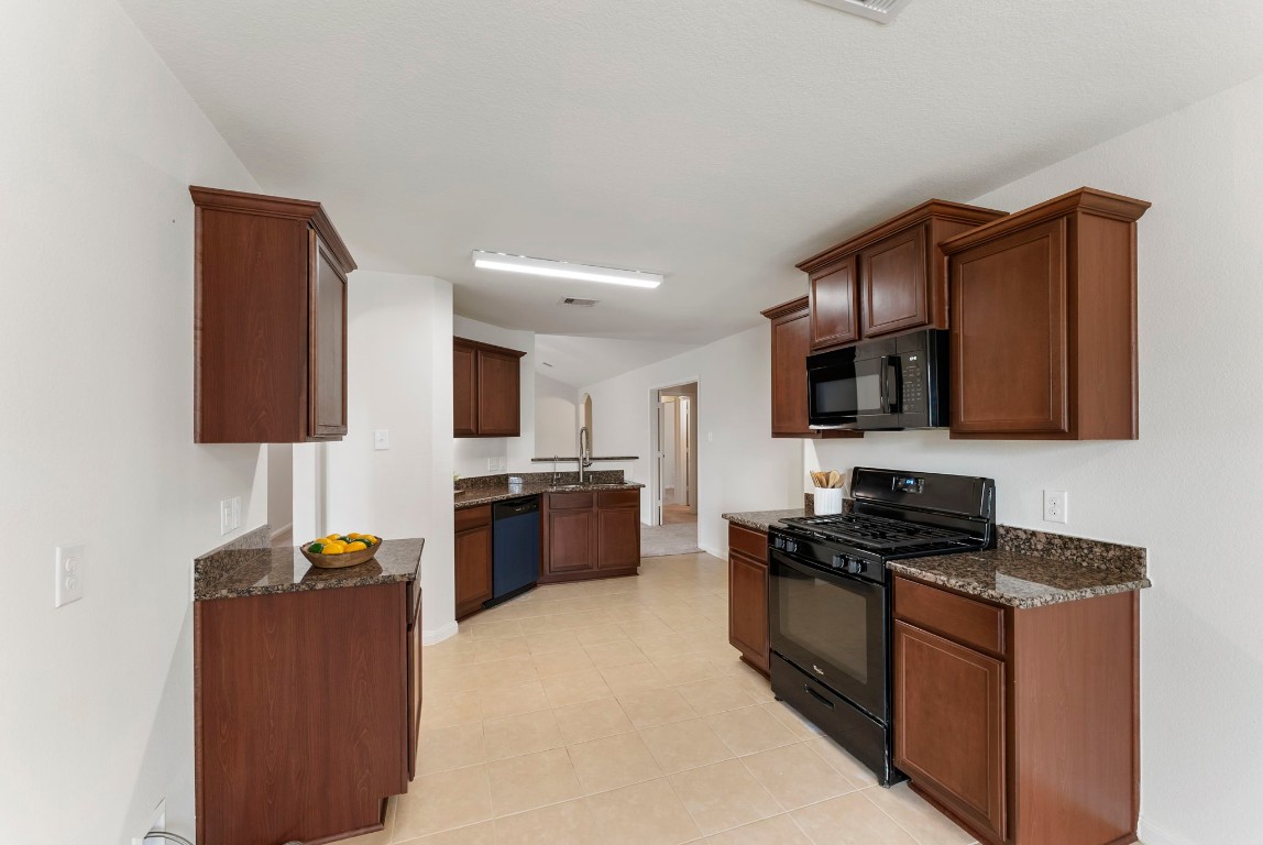 9159 Nina Road Conroe, TX 77304 - Photo 7 of 24 Plenty of cabinetry provides ample storage, with a sizable pantry conveniently located just around the corner for added organization.