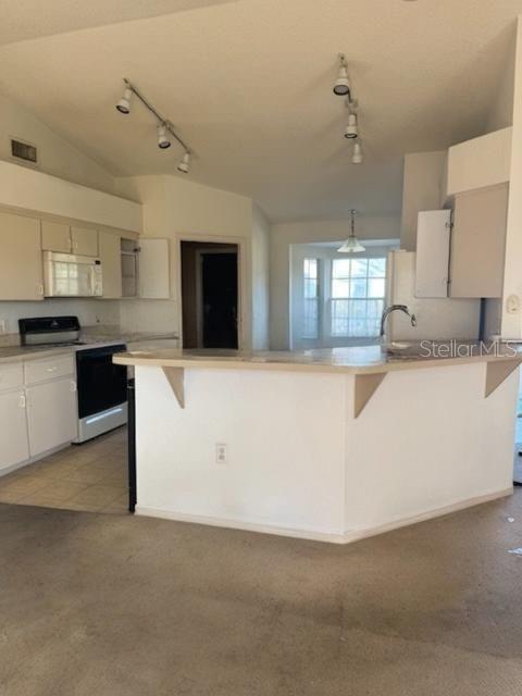 702 Tartan Loop Lake Wales, FL 33853 - Photo 7 of 20 a large kitchen with stainless steel appliances granite countertop a stove top oven a sink a refrigerator and white cabinets