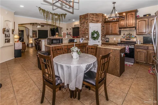a kitchen with stainless steel appliances a table and chairs in it