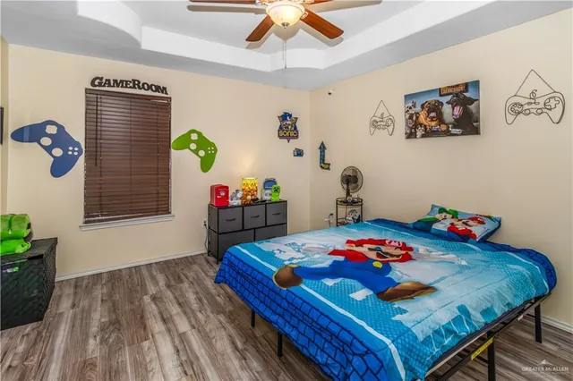 a bedroom with a bed a dresser and potted plants