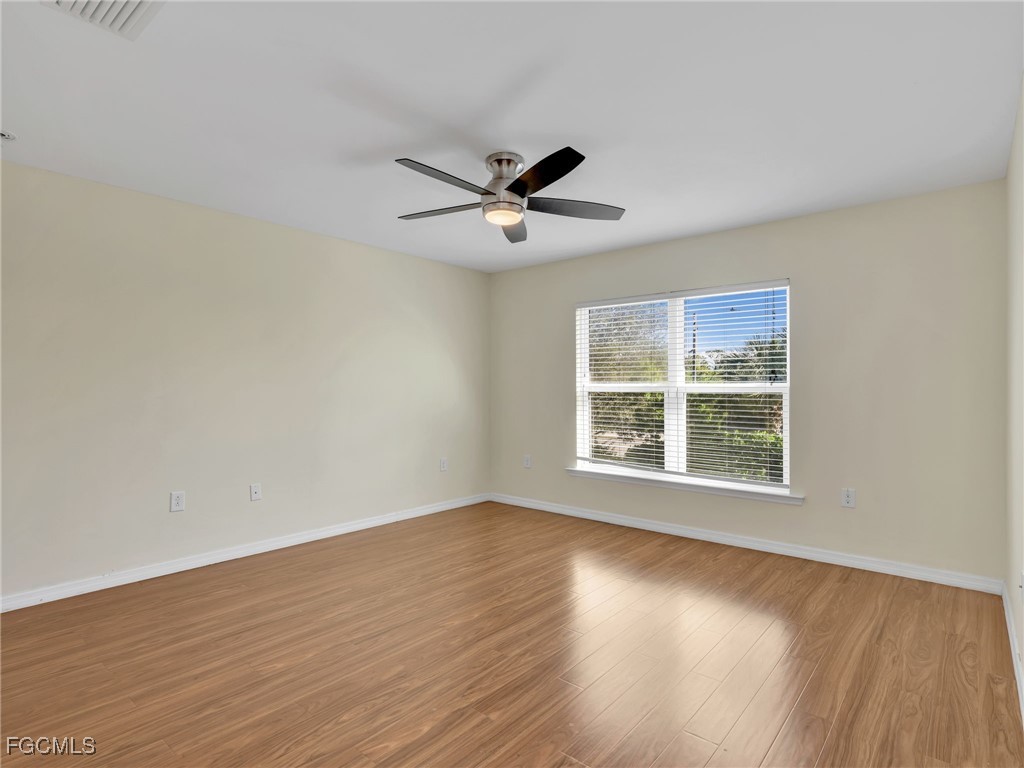 3886 Tilbor Circle Fort Myers, FL 33916 - Photo 19 of 30 a view of an empty room with wooden floor and a window