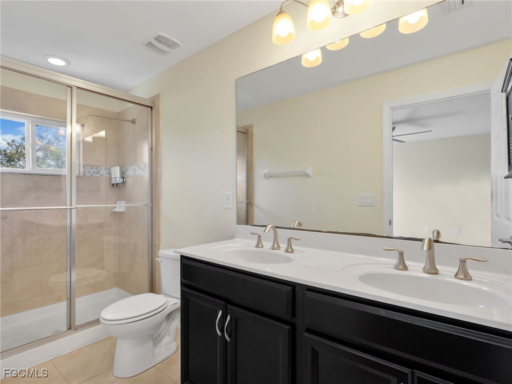 3886 Tilbor Circle Fort Myers, FL 33916 - Photo 21 of 30 a bathroom with a double vanity sink toilet and shower