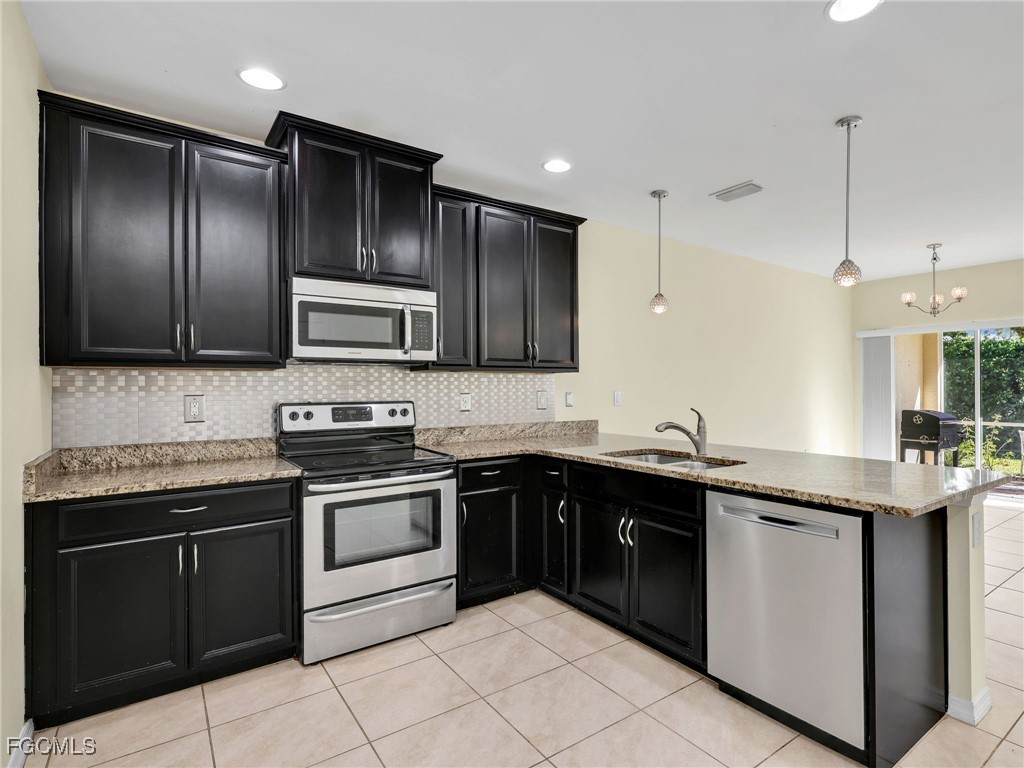 3886 Tilbor Circle Fort Myers, FL 33916 - Photo 7 of 30 a kitchen with a sink stove and microwave