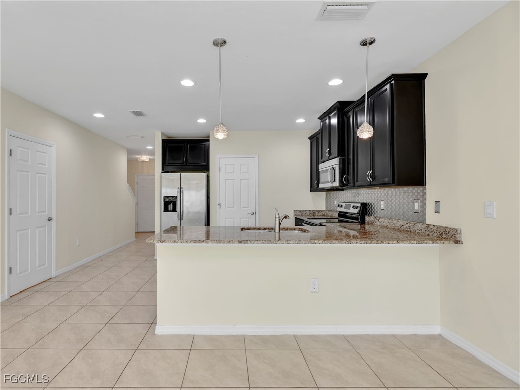 3886 Tilbor Circle Fort Myers, FL 33916 - Photo 9 of 30 a large white kitchen with a sink and cabinets