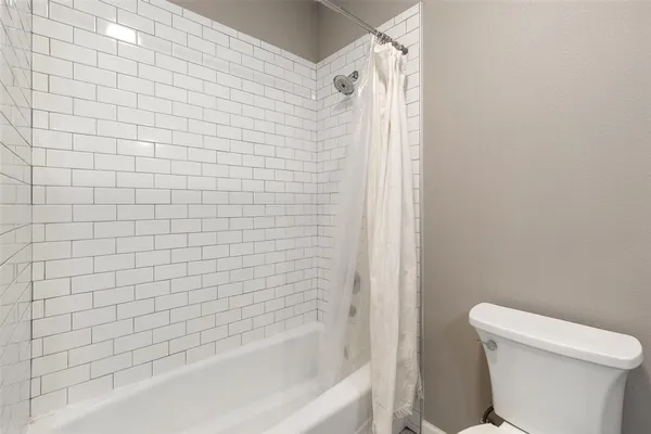 a bathroom with a white bathtub and a toilet
