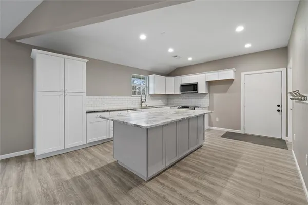 a kitchen with a sink cabinets and wooden floor