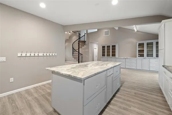 a kitchen with a stove and a wooden floor