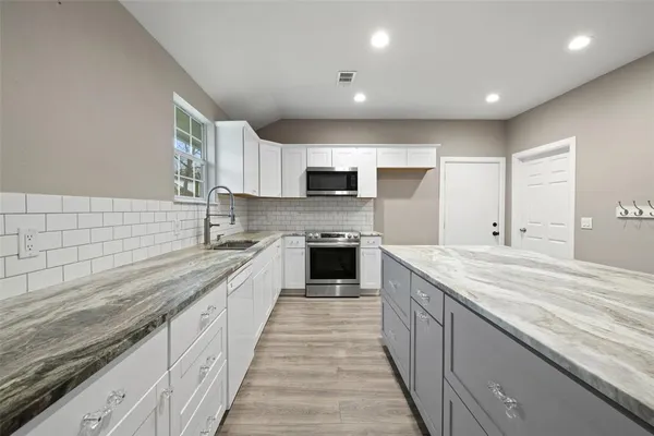 a large kitchen with a stove and cabinets