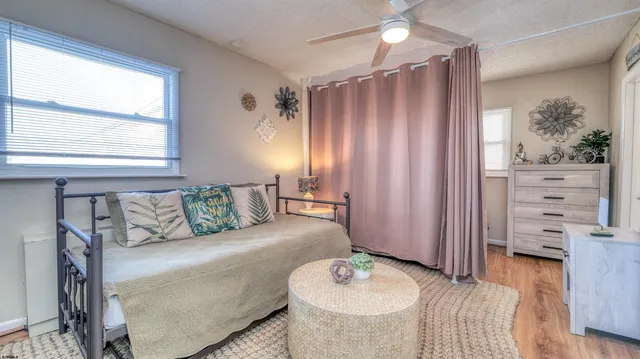 a living room with furniture a flat screen tv and a refrigerator